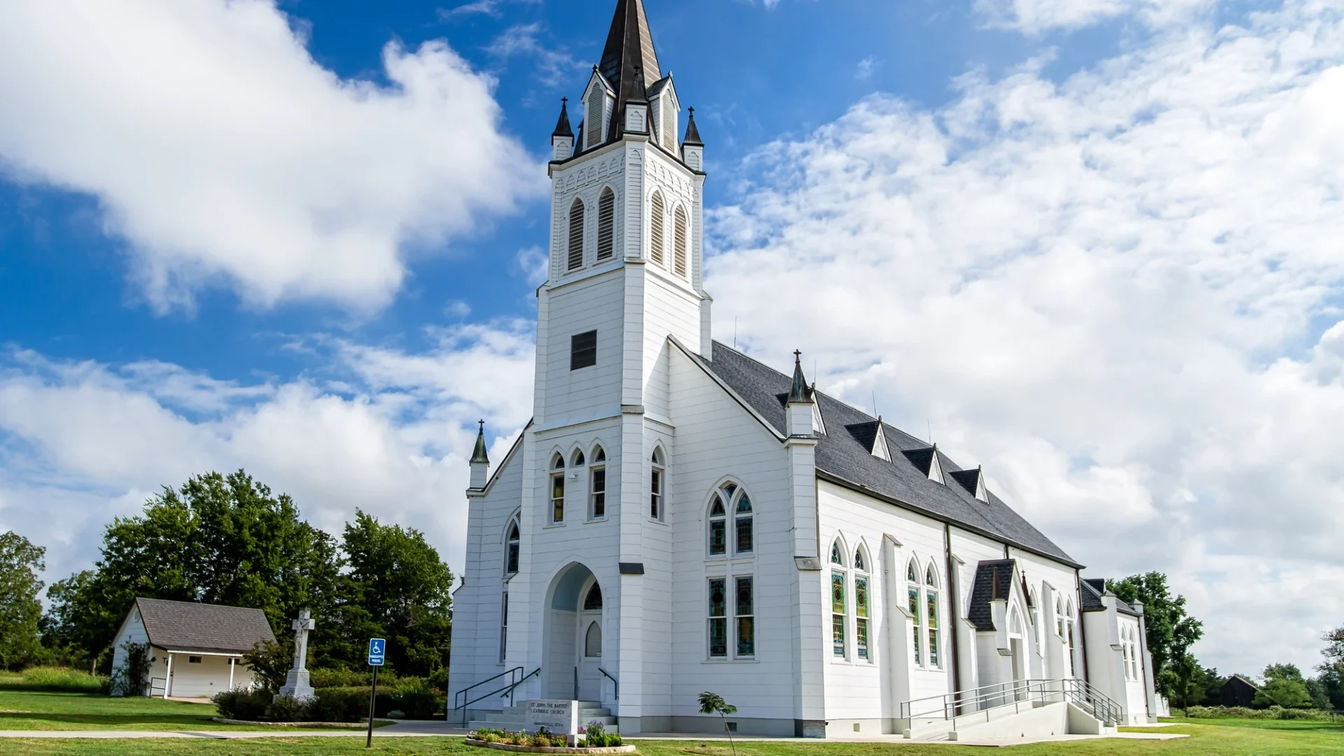 Church building with white siding and shingle roofing