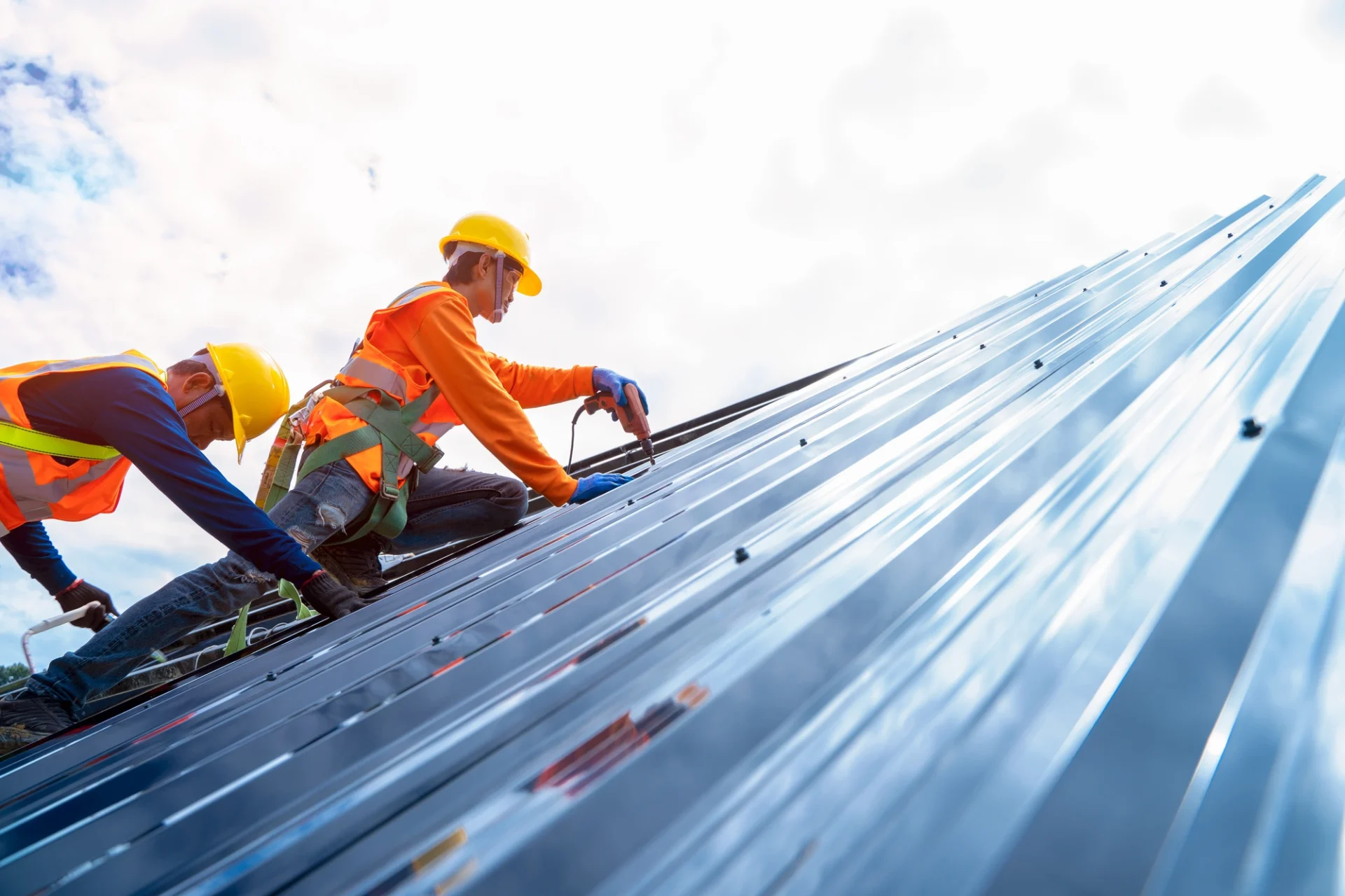 Workers completing roof repair on a metal roof
