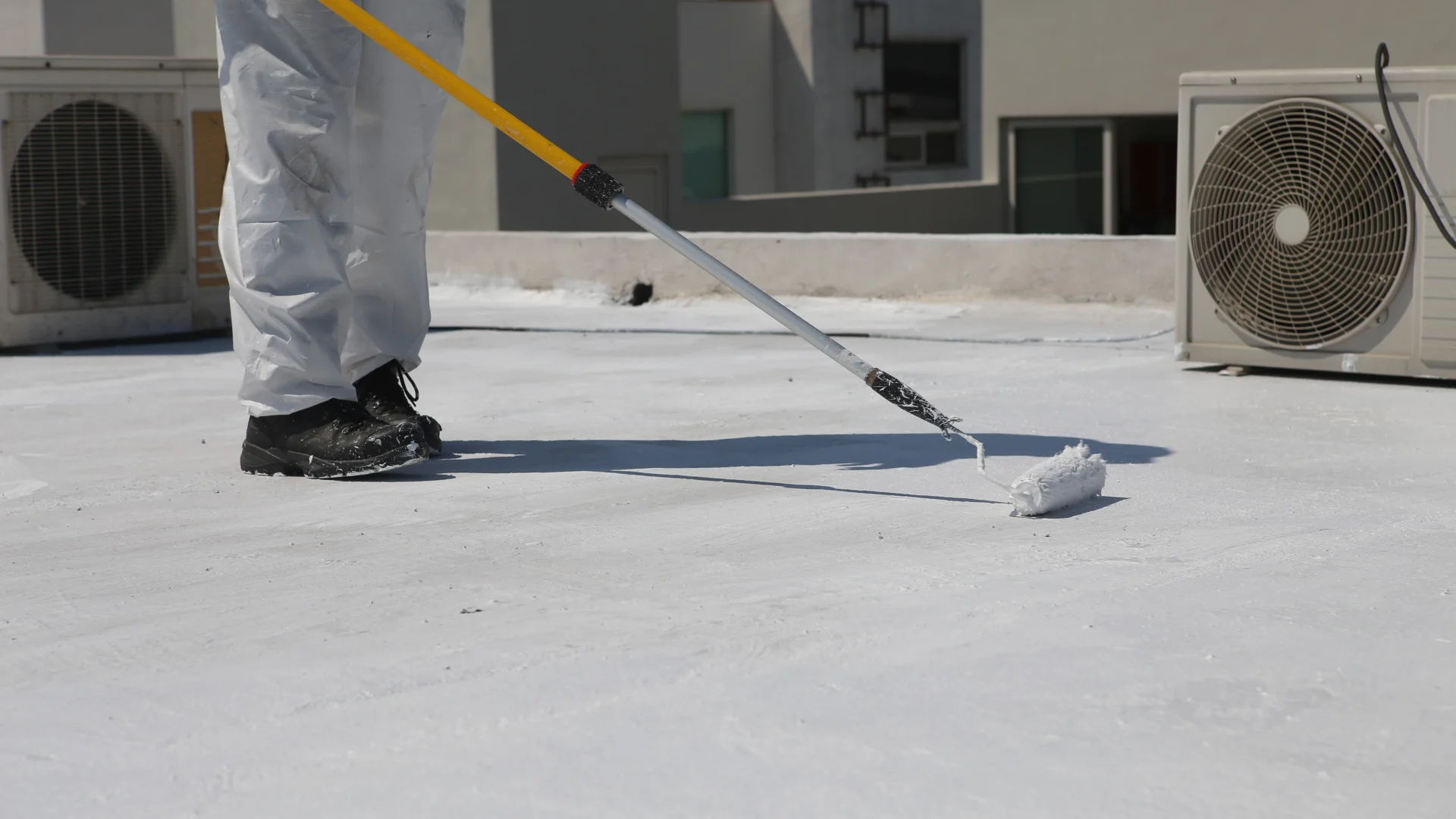 Close view of a roofer installing a waterproof roof coating