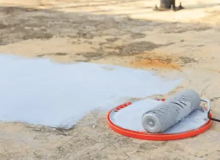 Roller With White Roof Coating On It Being Used On Roof