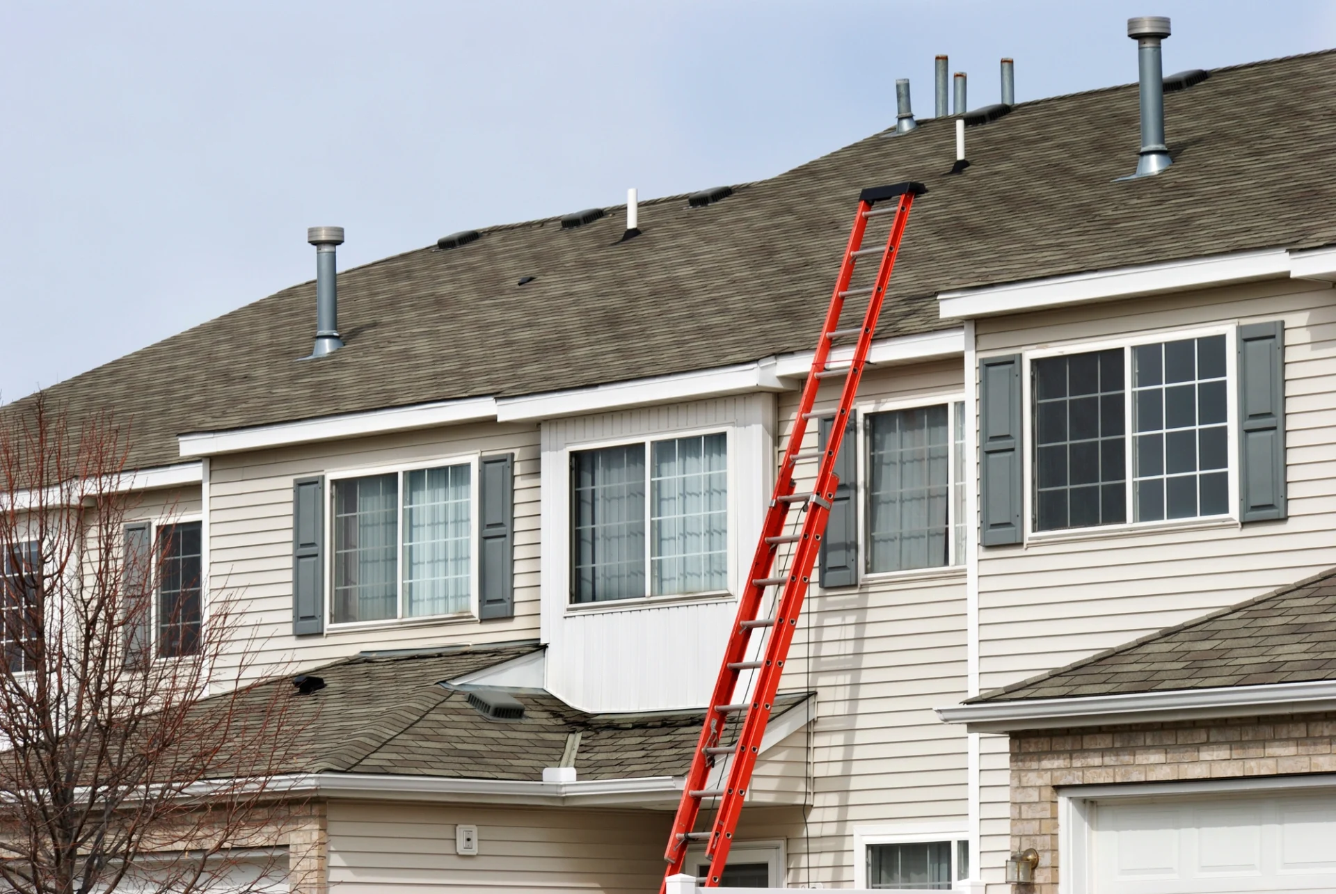 There’s a red ladder against a multi-family unit