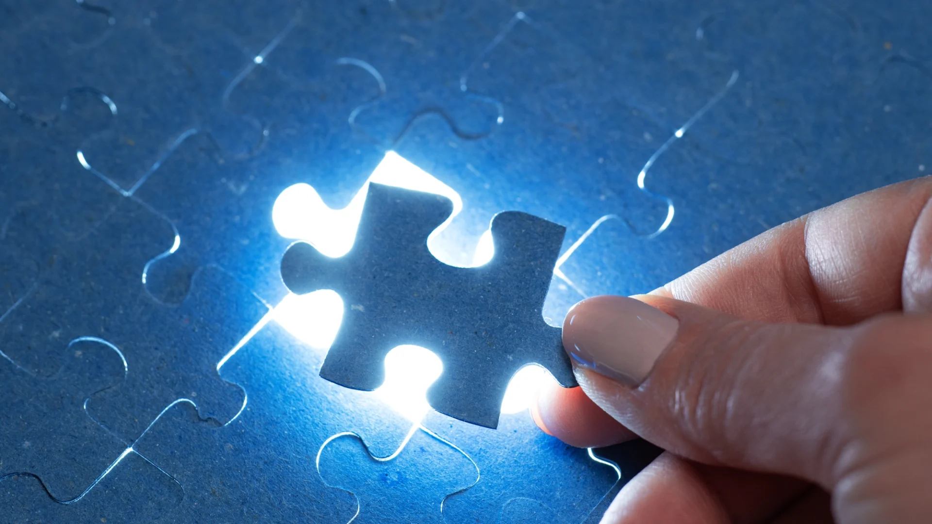 A hand places the final piece of a puzzle