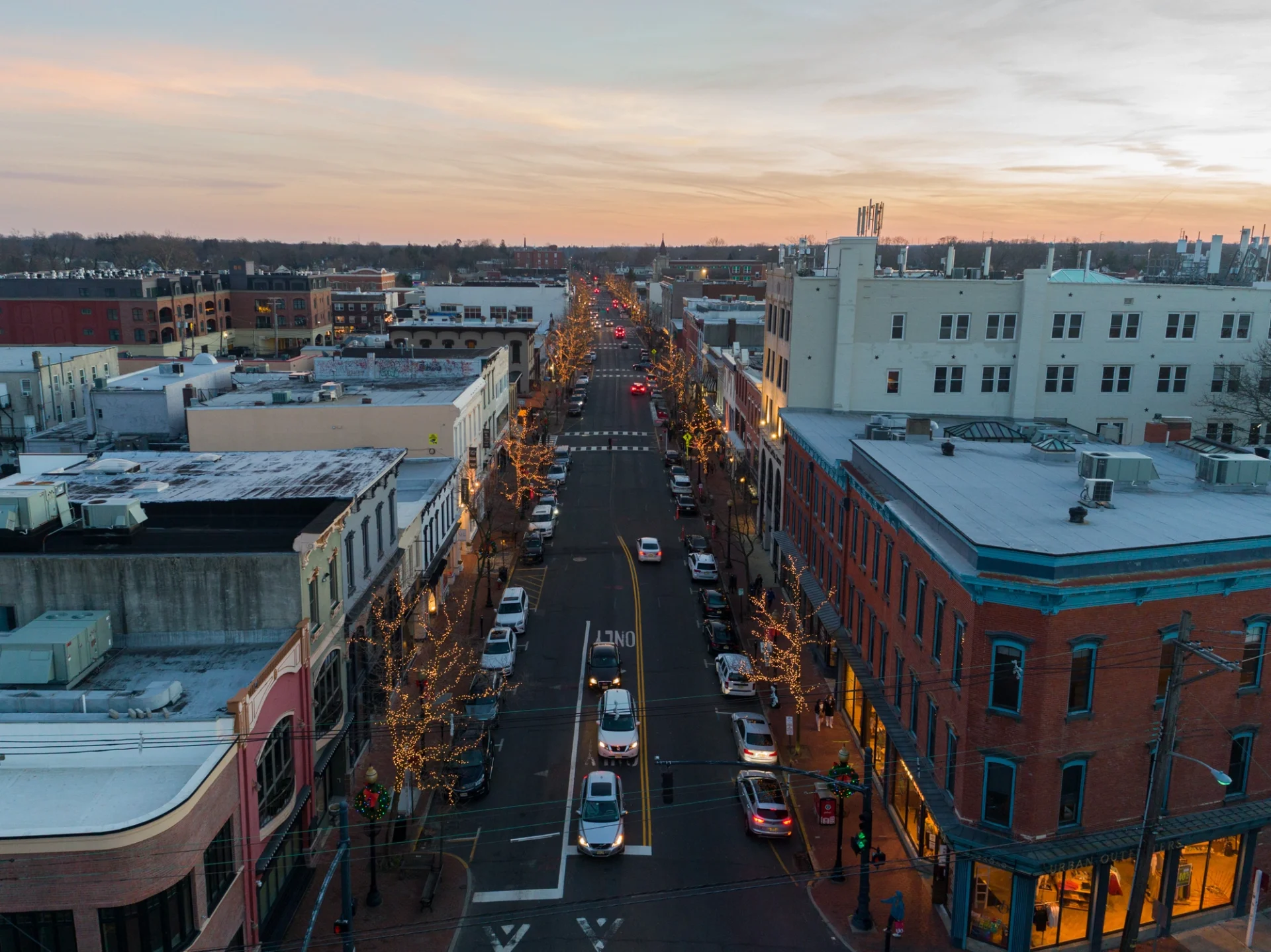 A landscape view of Broad Street in Newark, New Jersey, showing a variety of commercial roofs with cars coming and going down the street.