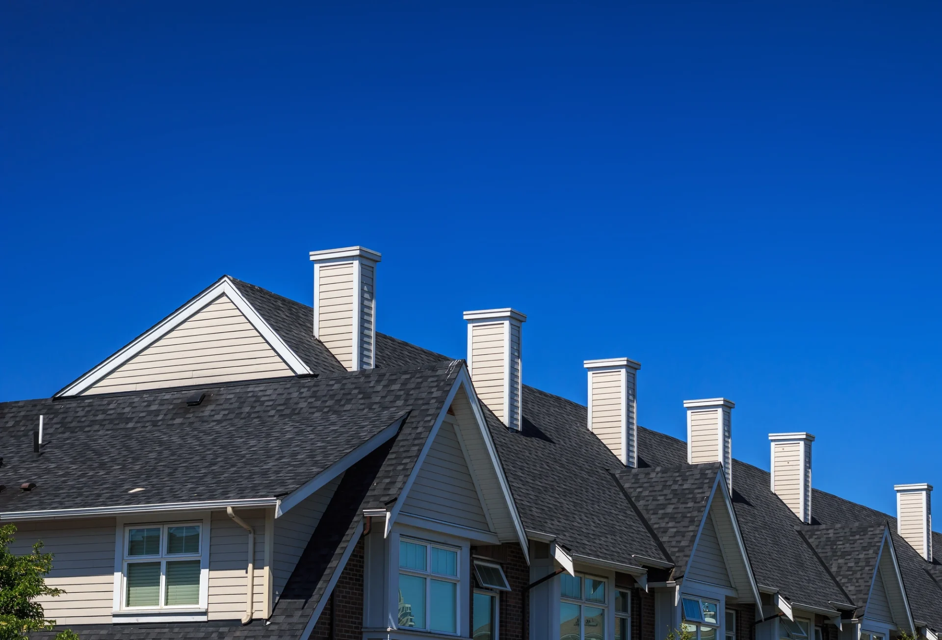 The dark shingled roof of a multi-family residential building