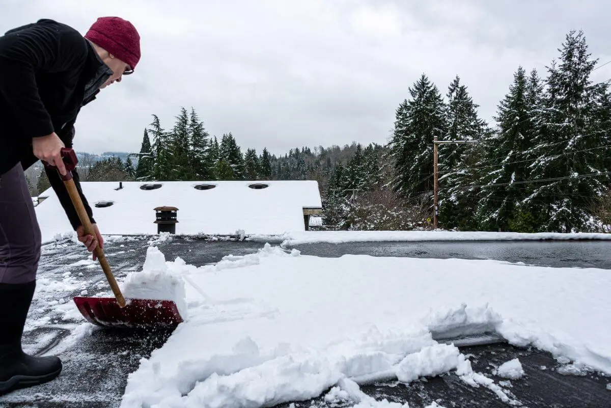 Flat Roofer Clearing Snow